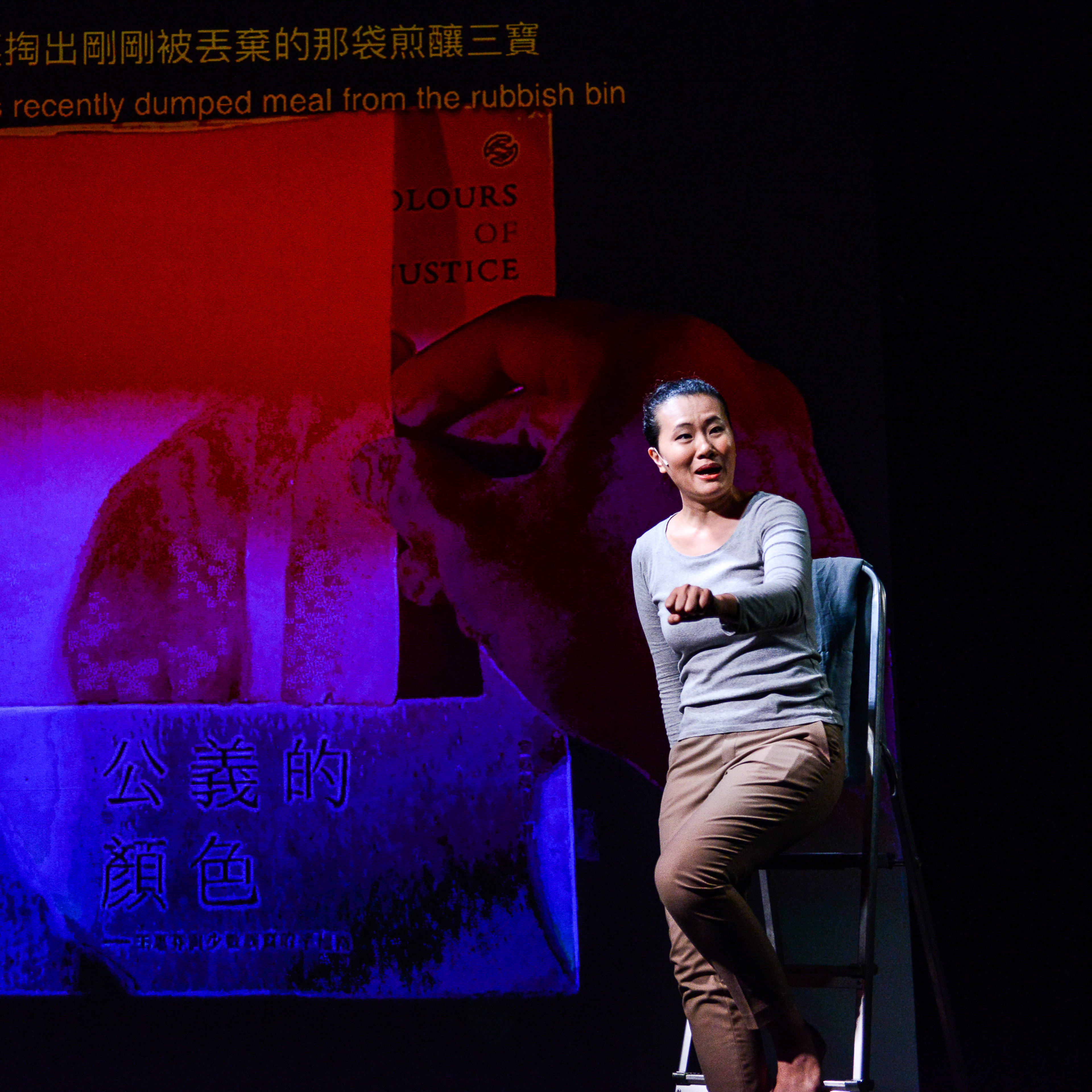 在天台製作的當代劇場作品《山下的證詞》（Testimony）中，演員李婉晶坐於舞台的梯子上，背景是一面深沉的投影，展示著一隻巨大的手伸向寫有「Colours of Justice」的紅色屏幕。舞台燈光運用強烈的藍紫對比，展現出香港當代劇場獨有的敘事張力。李婉晶在演出中動情地唸道：「從垃圾桶裏掏出剛剛被丟棄的那袋煎釀三寶」。