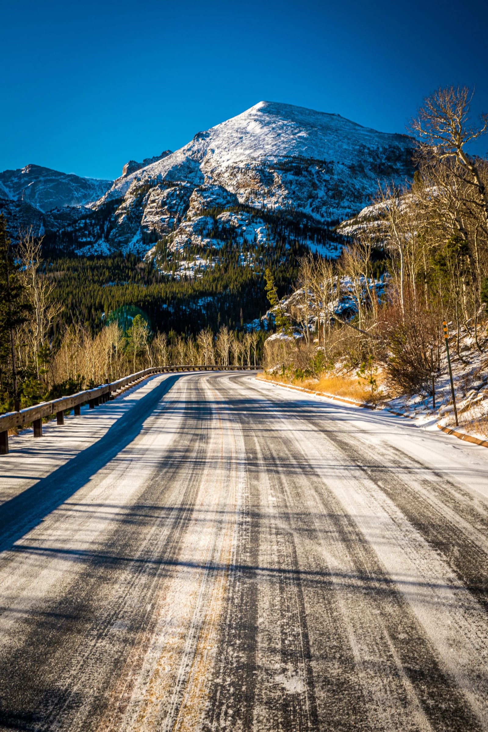 The Park Hands Out Previews — Rocky Mountain National Park, Colorado. A snow-covered peak framed by trees on the drive into Rocky Mountain National Park,…