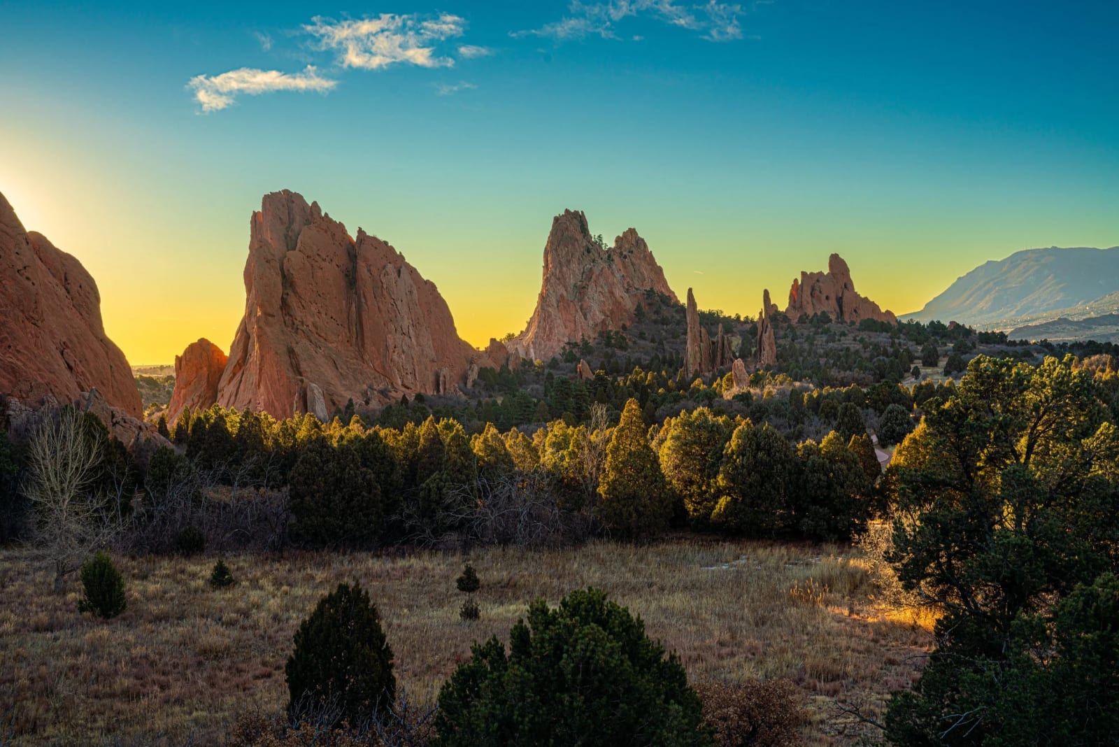 Pikes Peak Keeps an Eye on Things — Garden of the Gods, Colorado Springs, Colorado. The sun cresting behind the spires at Garden of the Gods with Pikes Peak…
