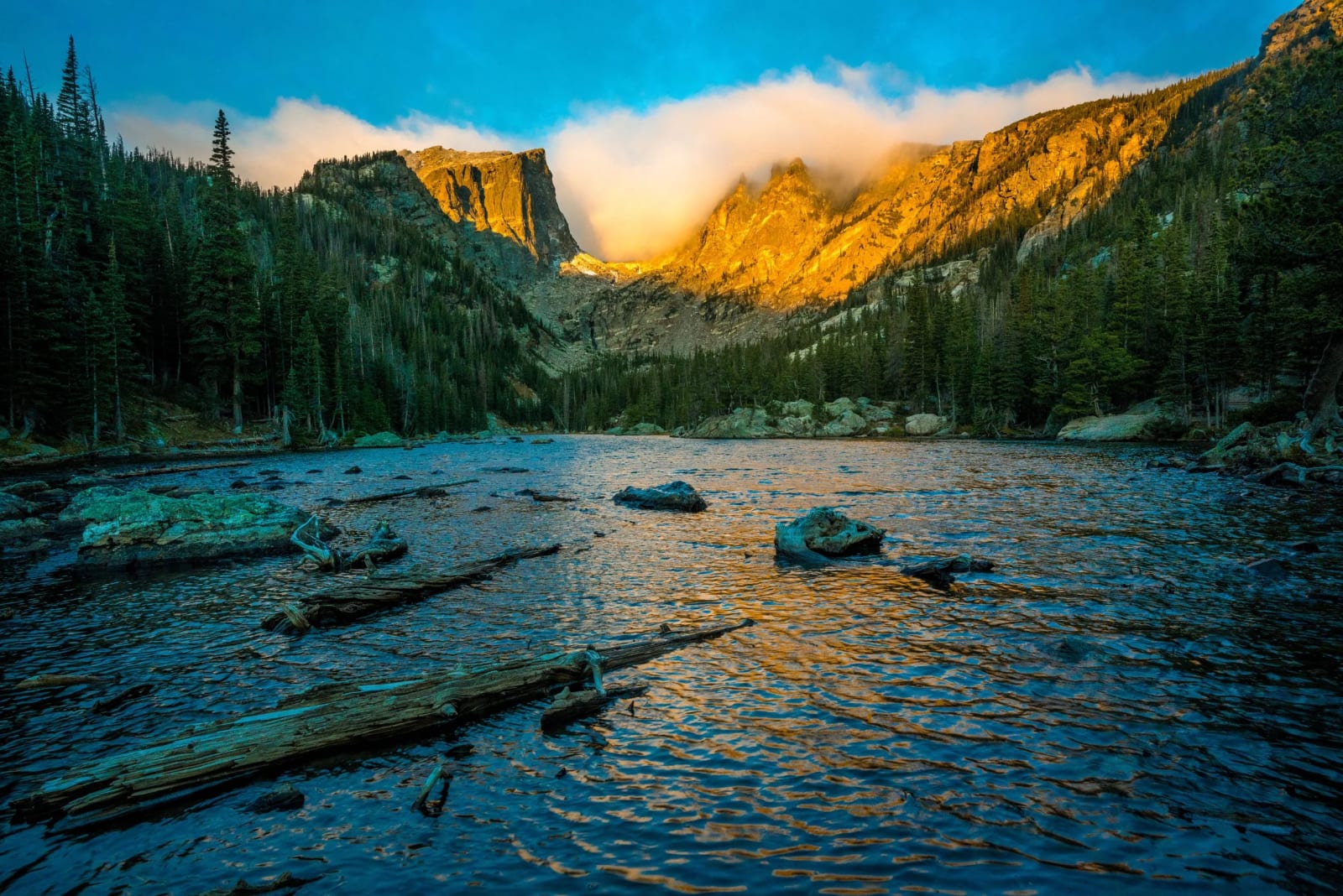 A Cloud Spills Over Hallett — Rocky Mountain National Park, Colorado. A cloud spilling over Hallett Peak while the sun works on the crags above Dream Lake…