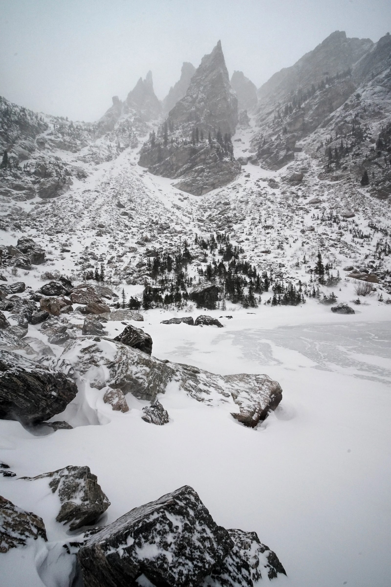 Whiteout at the Lake — Rocky Mountain National Park, Colorado. Snow coming in sideways over a frozen lake in Rocky Mountain National Park while the spires…