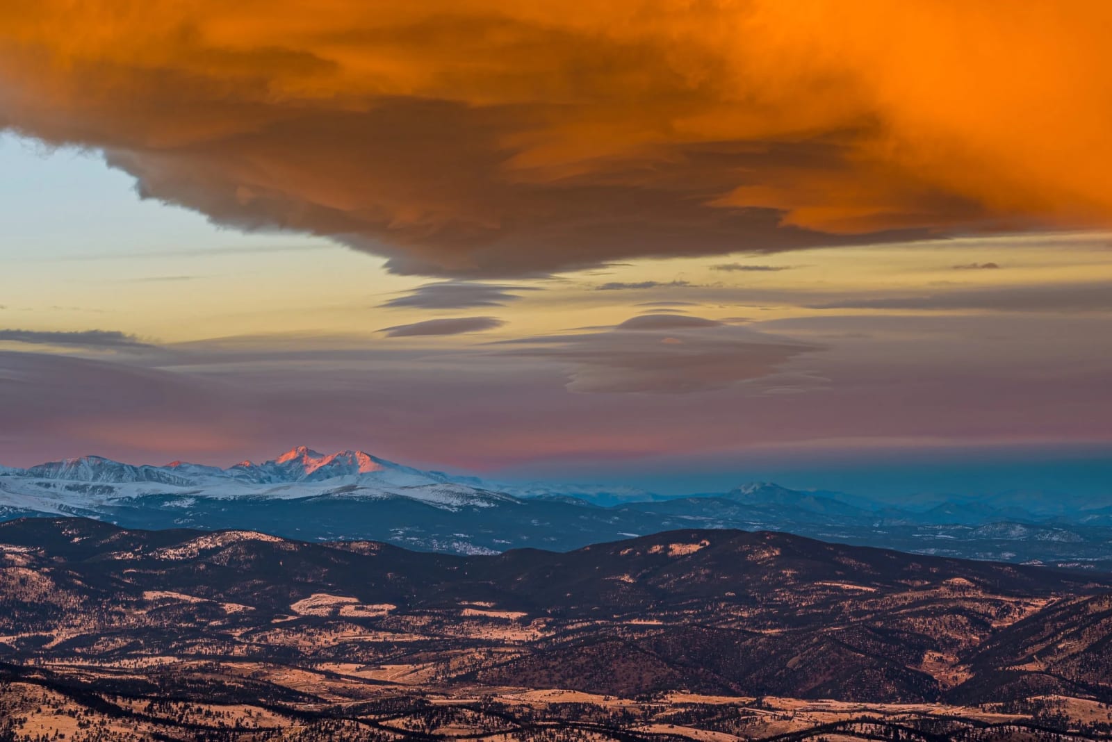 A Cloud the Size of a County — Mestaa'ehehe Mountain, Colorado. A lenticular cloud the size of a county turning orange over the Front Range foothills at…