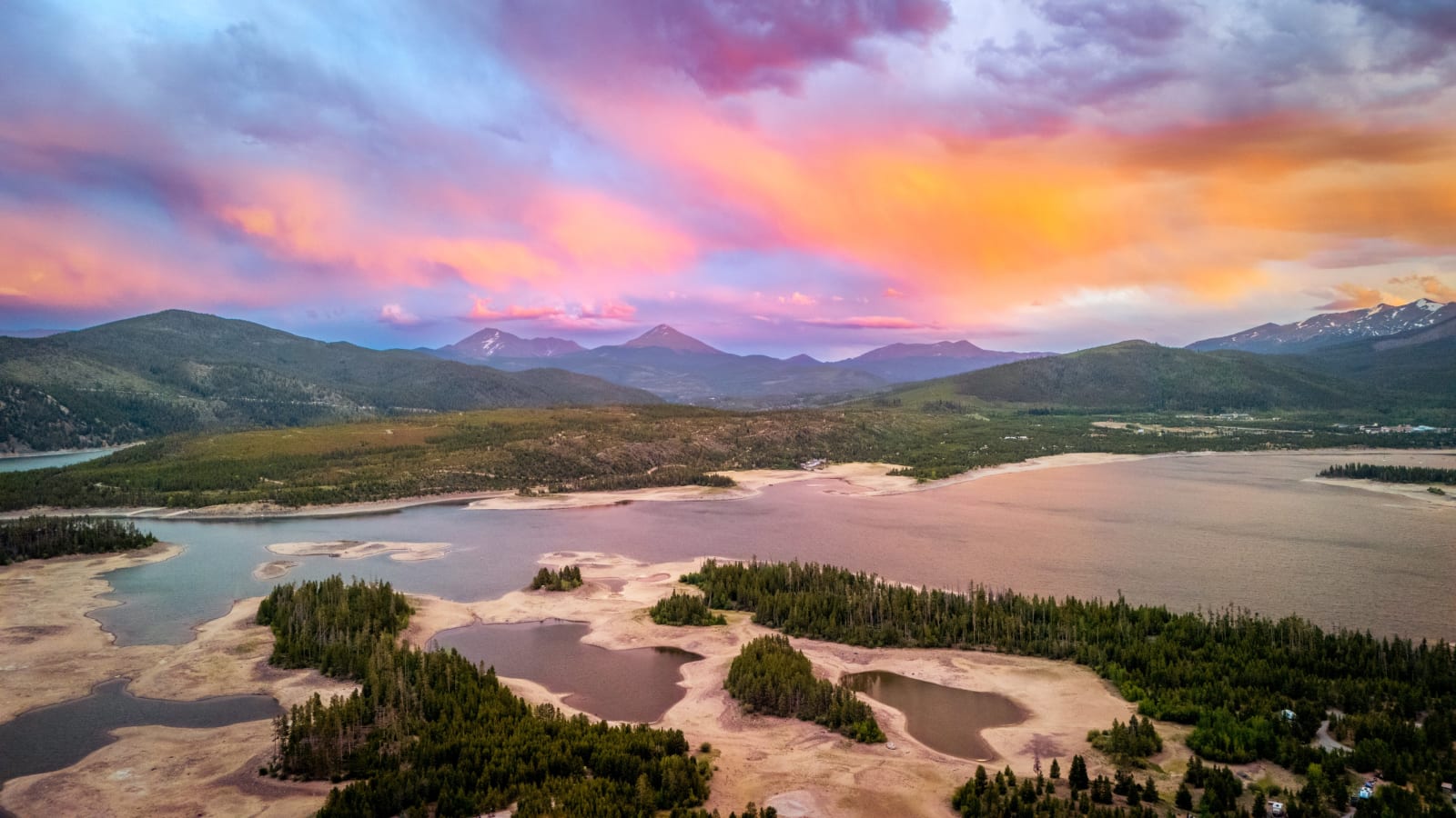 Dillon From Above — Lake Dillon, Colorado. Lake Dillon from the air at sunset, with cotton candy cloud stretched over the Gore Range and the drought-exposed…