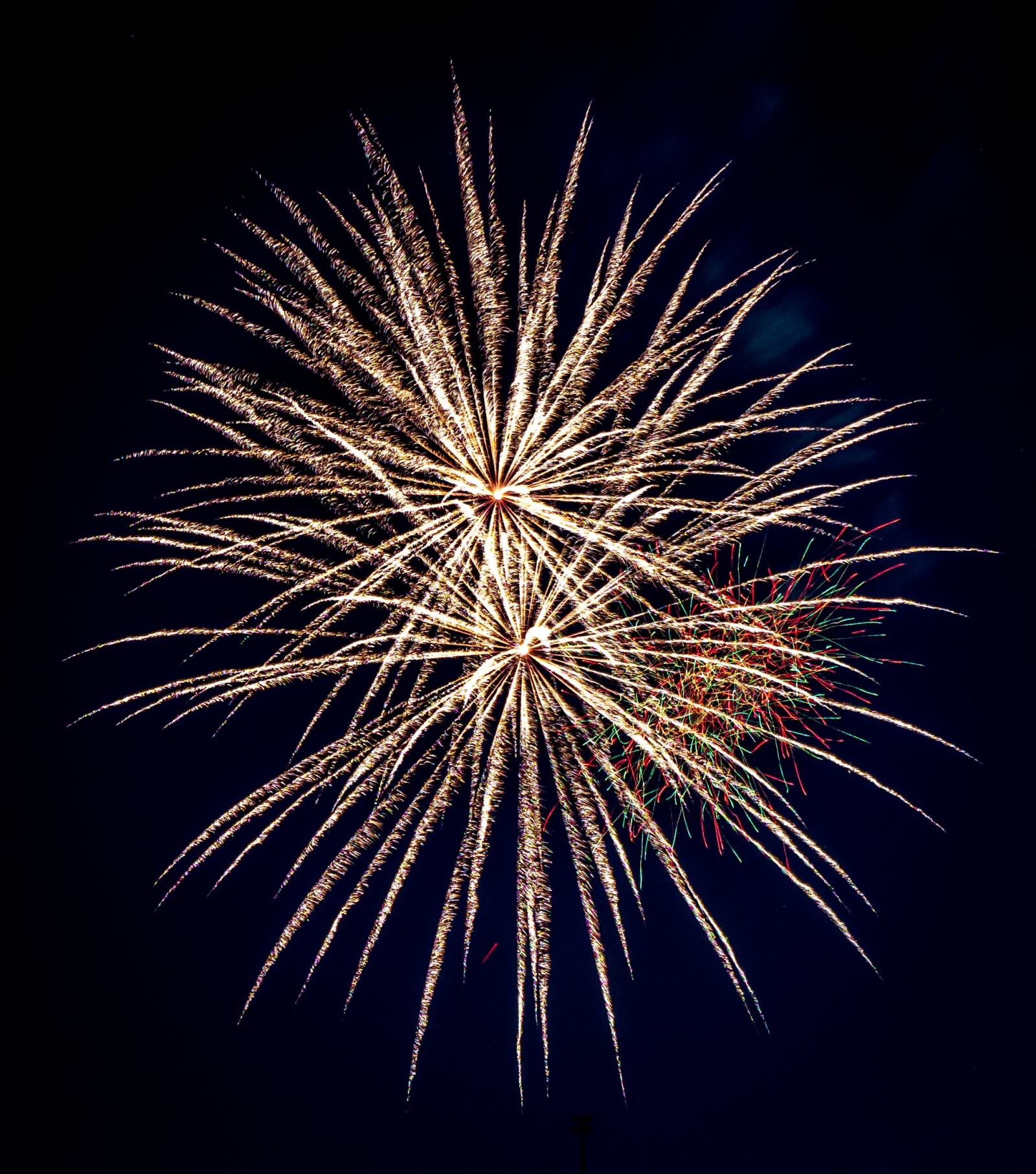 Fourth of July Over Arvada — Arvada, Colorado. A single firework bursting in a spray of gold and white over Arvada, Colorado, on the Fourth of July.