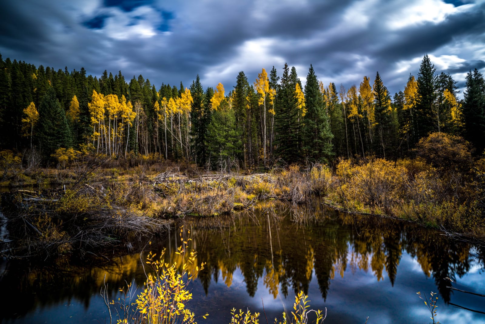 Beaver Pond Under Moving Clouds — Guanella Pass, Colorado. A 25-second exposure at a beaver pond near Guanella Pass, Colorado, blurs a stormy sky into soft…