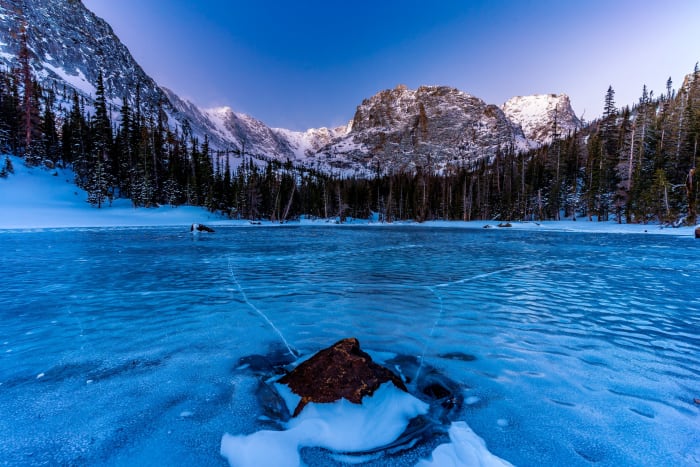 The Ice Pops and Groans — Rocky Mountain National Park, Colorado. Pressure cracks spidering out across the frozen surface of The Loch in the last blue light…