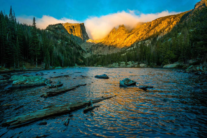 A Cloud Spills Over Hallett — Rocky Mountain National Park, Colorado. A cloud spilling over Hallett Peak while the sun works on the crags above Dream Lake…