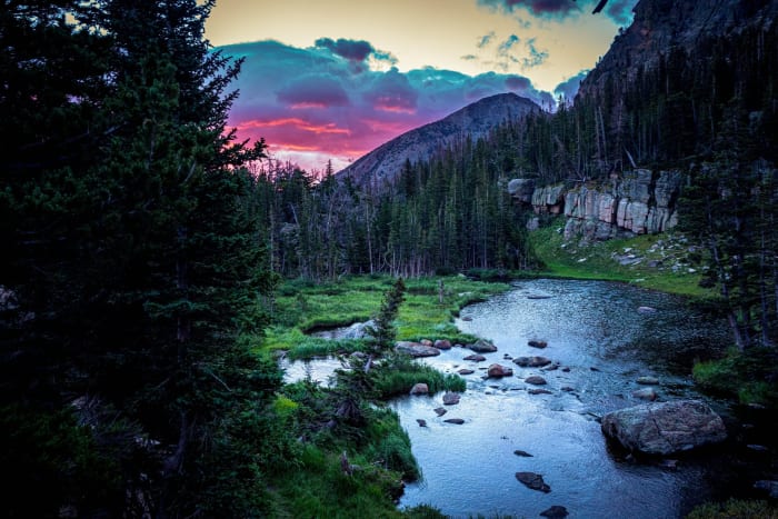 Ten Minutes to Headlamp — Rocky Mountain National Park, Colorado. The last pink of the day hanging over a quiet alpine tarn, dark spruce crowding both banks…