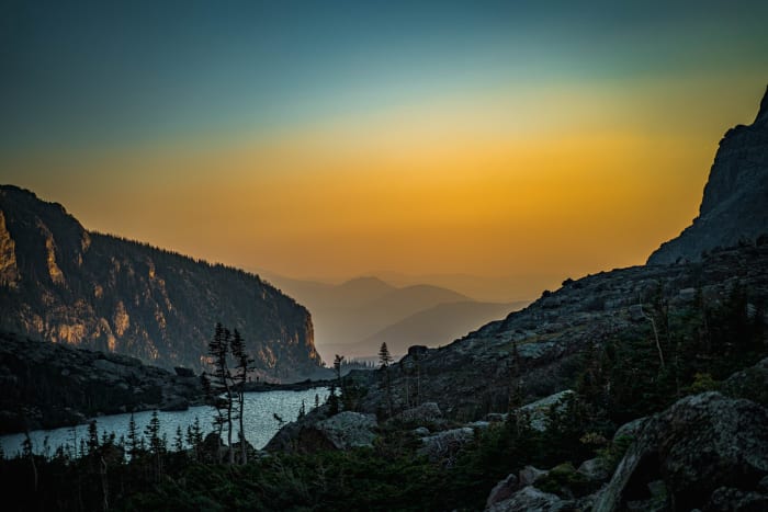Amber Glass — Rocky Mountain National Park, Colorado. Looking down a Colorado valley as summer haze turned the sunrise into a sheet of amber glass, the…