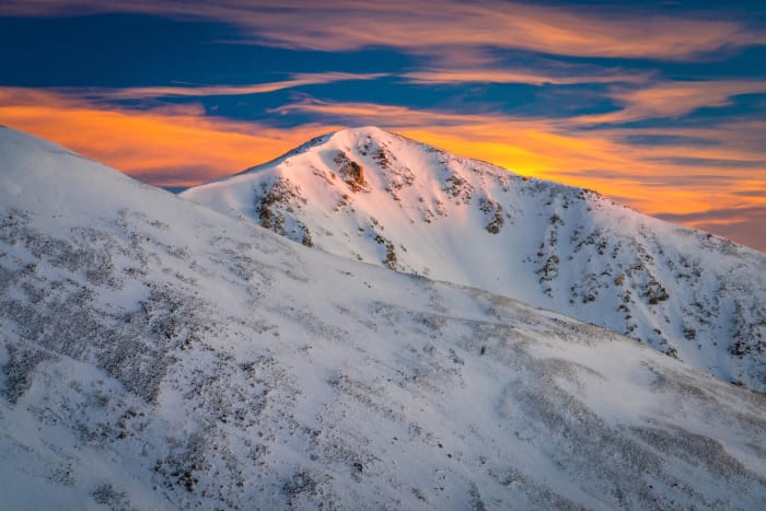 Divide in Winter Gold — Loveland Pass, Colorado. Sunrise sliding across a wind-scoured ridge on the Continental Divide at Loveland Pass, Colorado, snow…