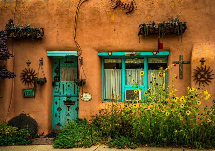 Southwest Soul — Taos, New Mexico. An adobe wall in Taos, New Mexico, warm in the late-afternoon light, with turquoise doors and window frames, hanging…