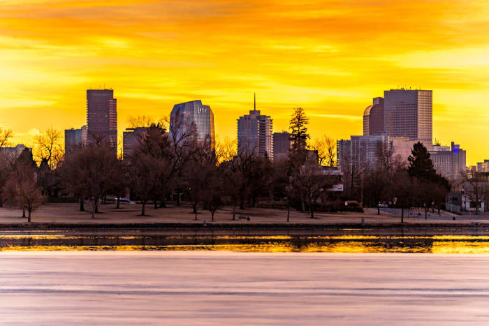 Good Morning, Denver — Sloan's Lake, Denver. Sunrise behind the Denver skyline from Sloan's Lake, Colorado, with the sky glowing yellow and orange behind…