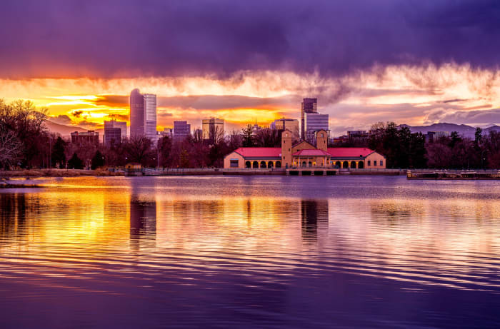 Skyline Over the Pavilion — City Park, Denver. A tighter view of the Denver skyline over Ferril Lake in City Park, Colorado, as the sun sets behind the…