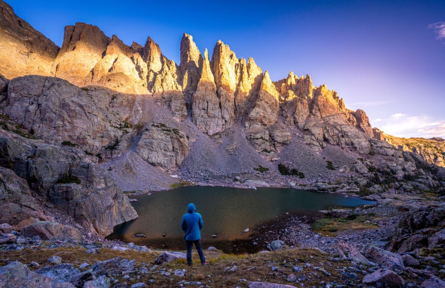 Chris Heaton in the field near a frozen alpine lake and dramatic rock spire