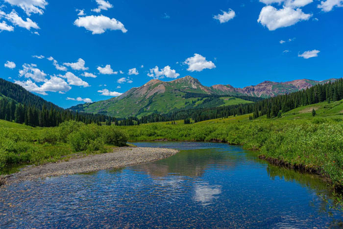 Knee-Deep Summer — Gothic, Colorado. Knee-deep summer green running up the valley toward Gothic, Colorado, with the river running clear over the cobbles and…