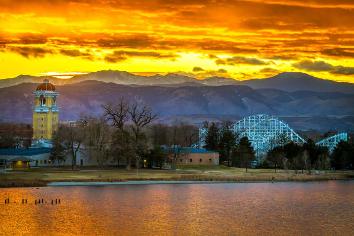Sunset Over the Midway — Berkeley Lake Park, Denver. Sunset burning orange over Berkeley Lake in Denver, with the Lakeside Amusement Park tower and the old…