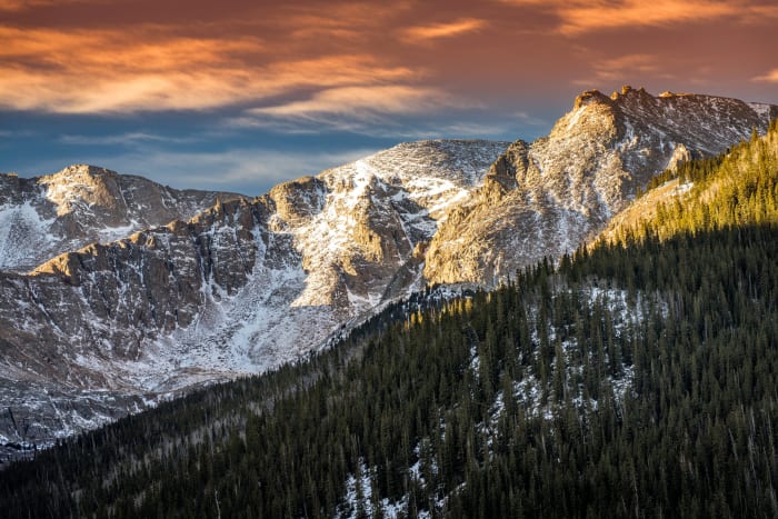 Frozen Above Idaho Springs — Idaho Springs, Colorado. A snow-plastered peak above Idaho Springs, Colorado catching the first warm light while the forest…