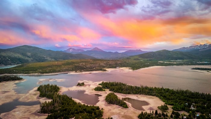 Dillon From Above — Lake Dillon, Colorado. Lake Dillon from the air at sunset, with cotton candy cloud stretched over the Gore Range and the drought-exposed…