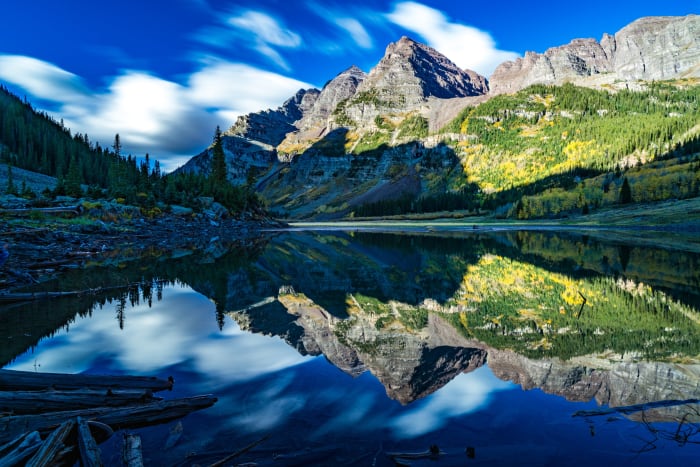 Clouds in a Hurry — Maroon Bells, Aspen, Colorado. A long exposure at Maroon Lake in Aspen, Colorado that turns a busy blue sky into soft streaks of cloud…