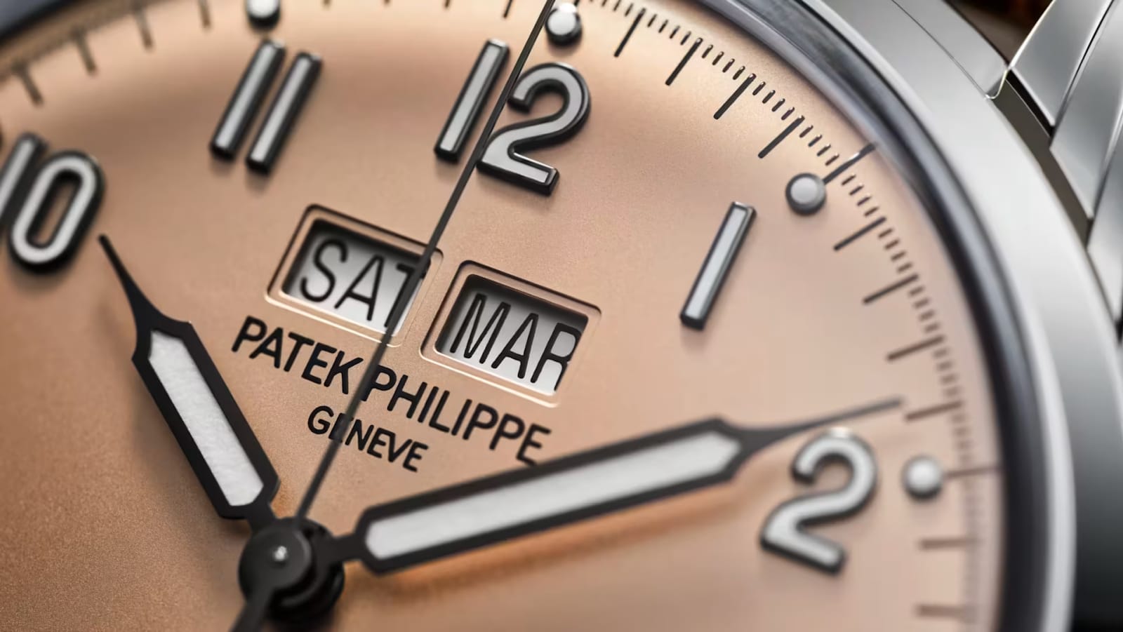 Close view of the dial: day and month windows, applied numerals and syringe hands