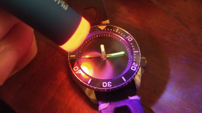 UV torch illuminating UV hands on watch