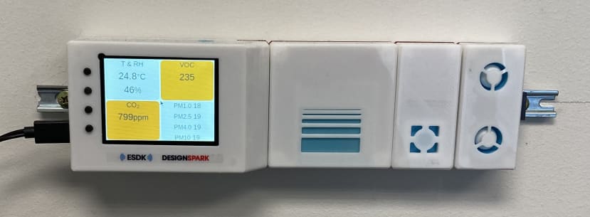 Close-up picture of the ESDK. Readings are (clockwise from top-left): temperature 24.8℃, humidity 46%, VOC index 235, CO2 799 ppm, PM1-10 18/19 µg/m3