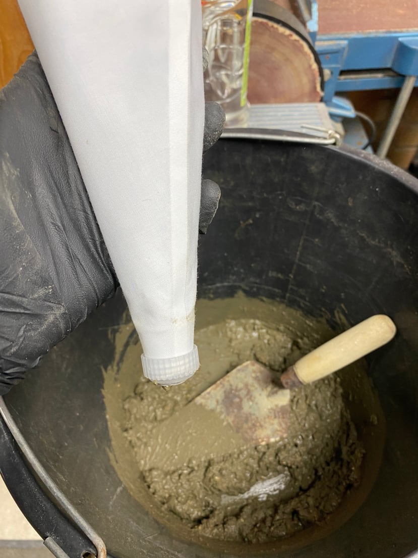 Bucket of concrete and bag for 3D printing