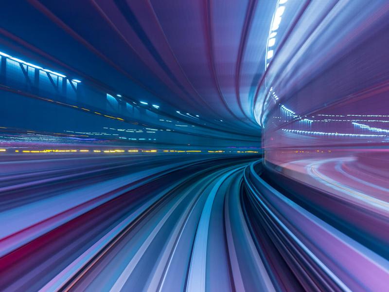 Abstract purple and blue light trails representing rapid business growth and tax governance