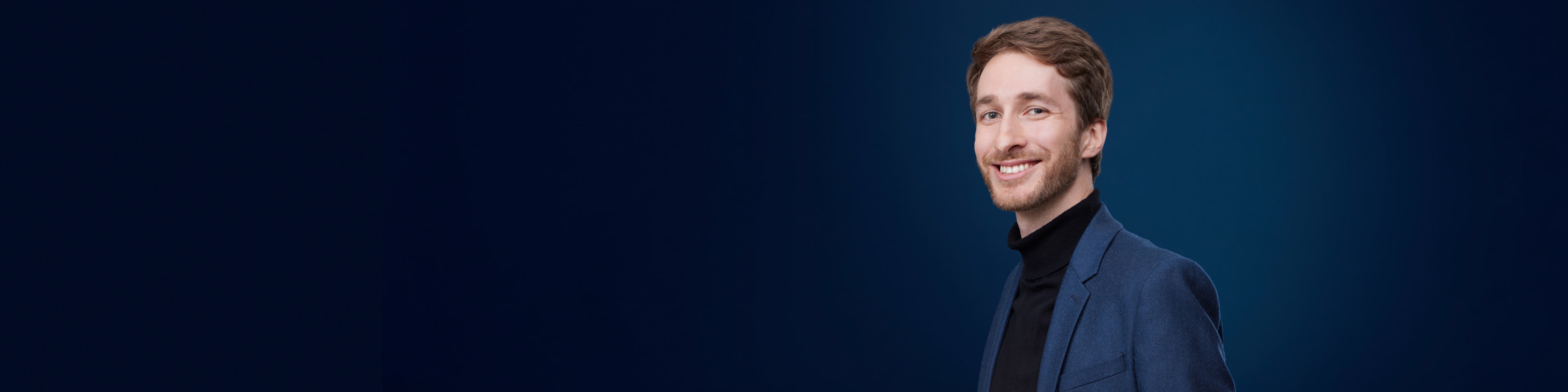 An elegant, smiling man with brown hair