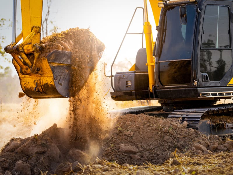 Close-up of excavator at construction site. Backhoe digging soil for earthwork and construction business