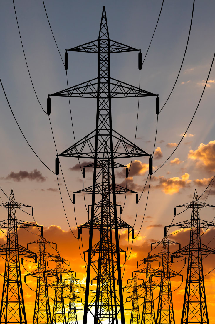 High-voltage power lines against a sunset backdrop