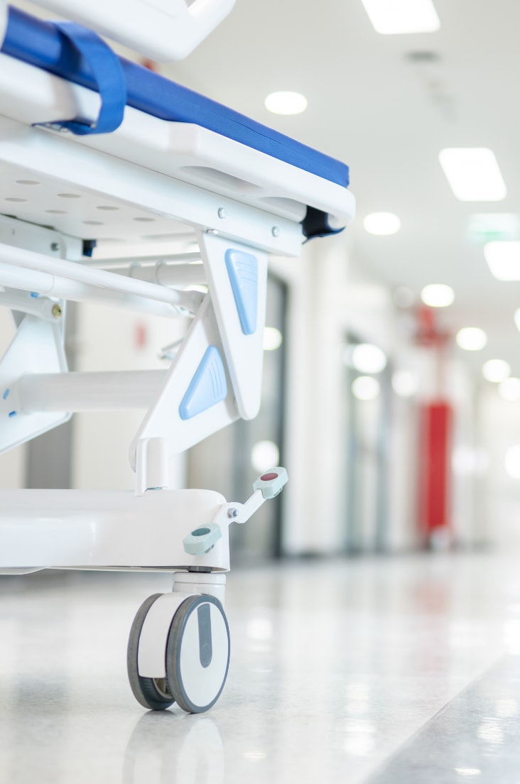 A hospital bed in a white corridor