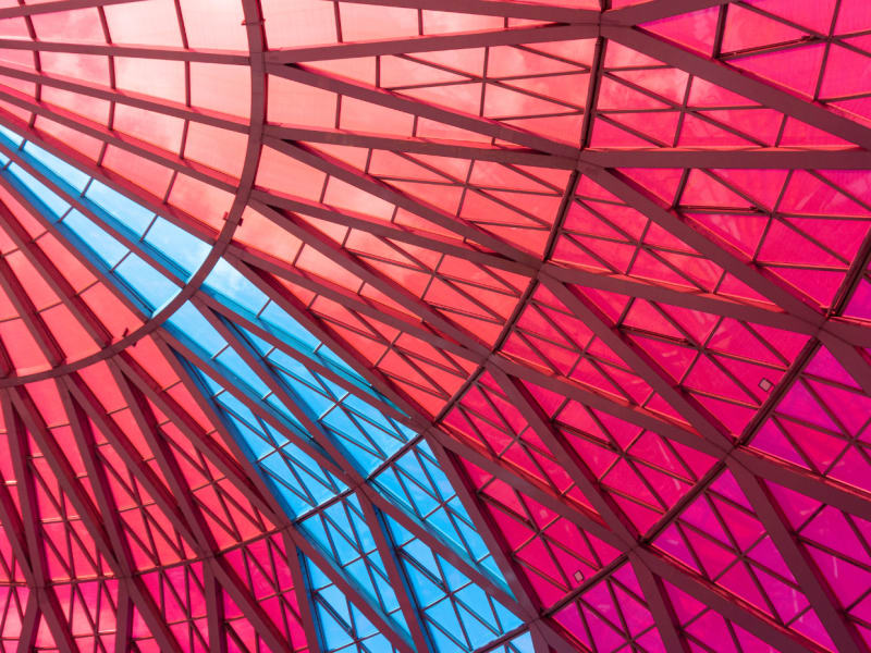 Semitransparent red glass ceiling with clear blue sky stripe