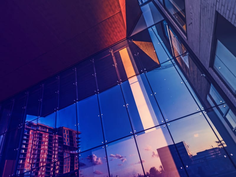 Buildings reflected in the glass window of an office building