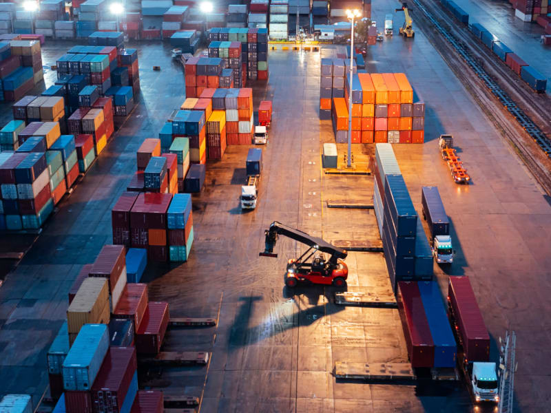 Aerial view forklift handling container load to container truck at container warehouse for business logistics, import export, shipping or freight transportation
