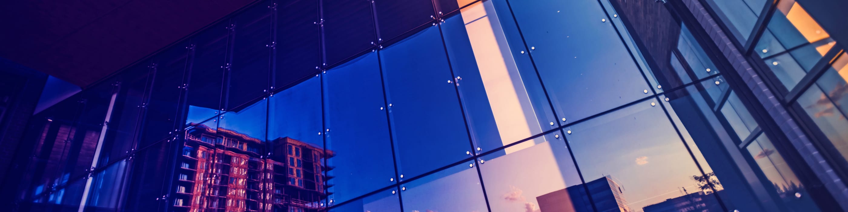 Buildings reflected in the glass window of an office building