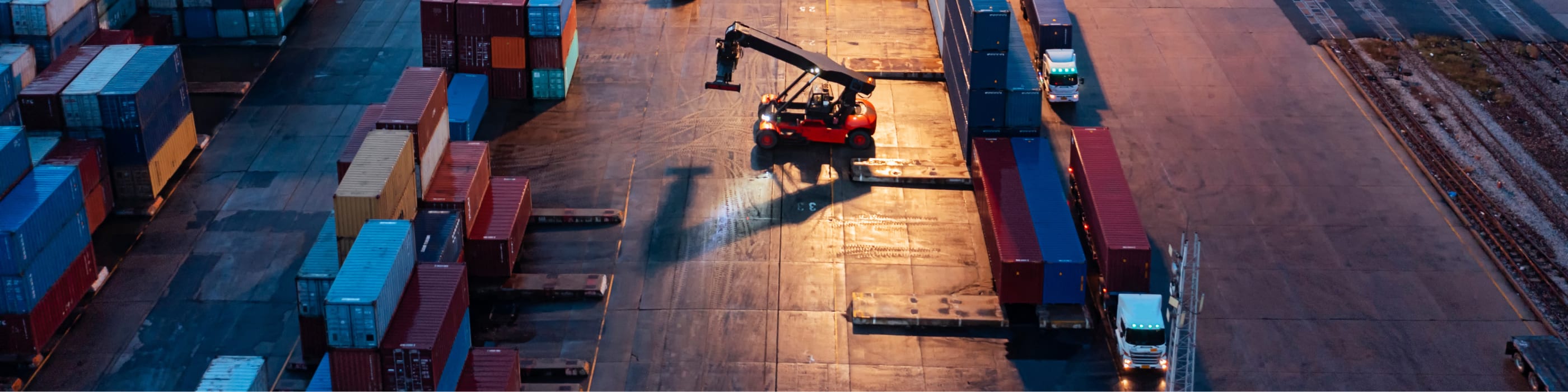 Aerial view forklift handling container load to container truck at container warehouse for business logistics, import export, shipping or freight transportation