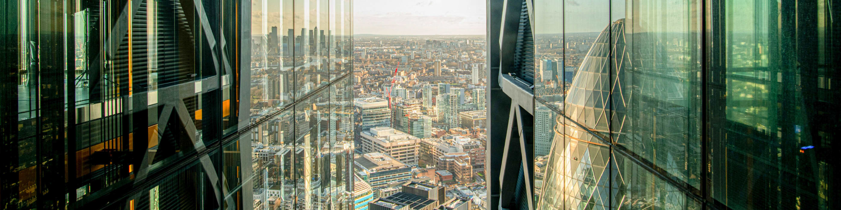 A panoramic view of the city visible between two glass skyscrapers