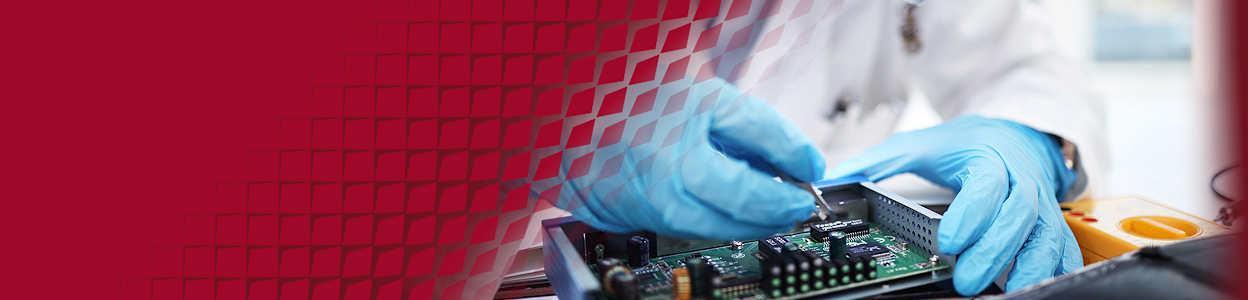 A technician wearing blue gloves, inspecting a circuit board for overheating issues.