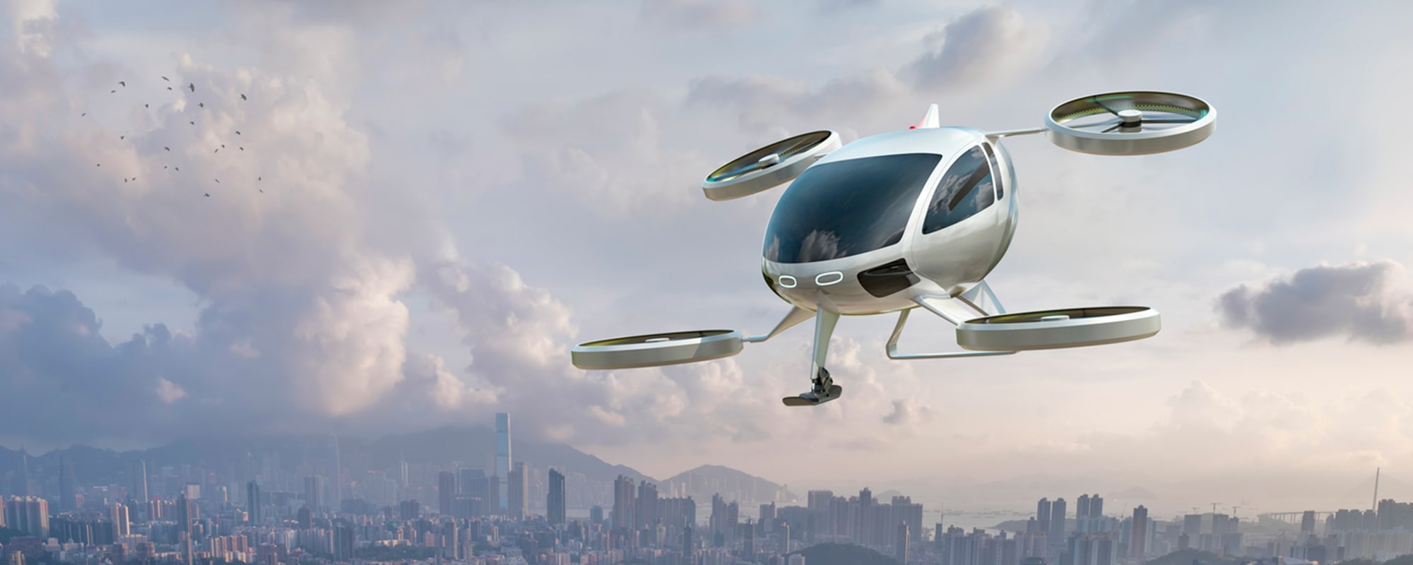 A futuristic flying vehicle with circular propellers gliding through the air with a distant city and mountains in the background.
