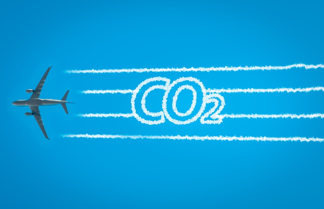 Plane flying with CO2 written in its emissions trail