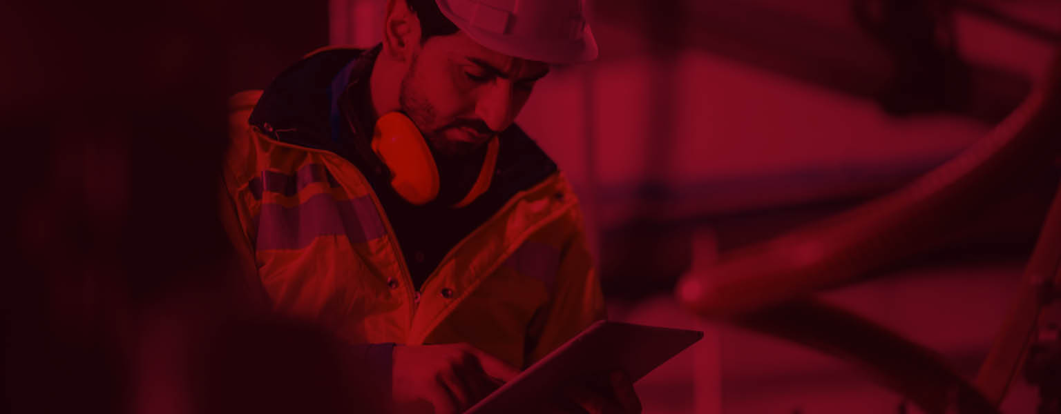 A man in PPE using a tablet to inspect something