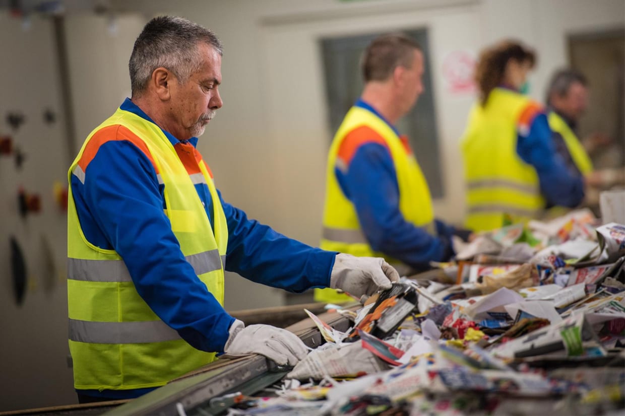 Imagen de varios trabajadores tratando con residuos con equipación de seguridad