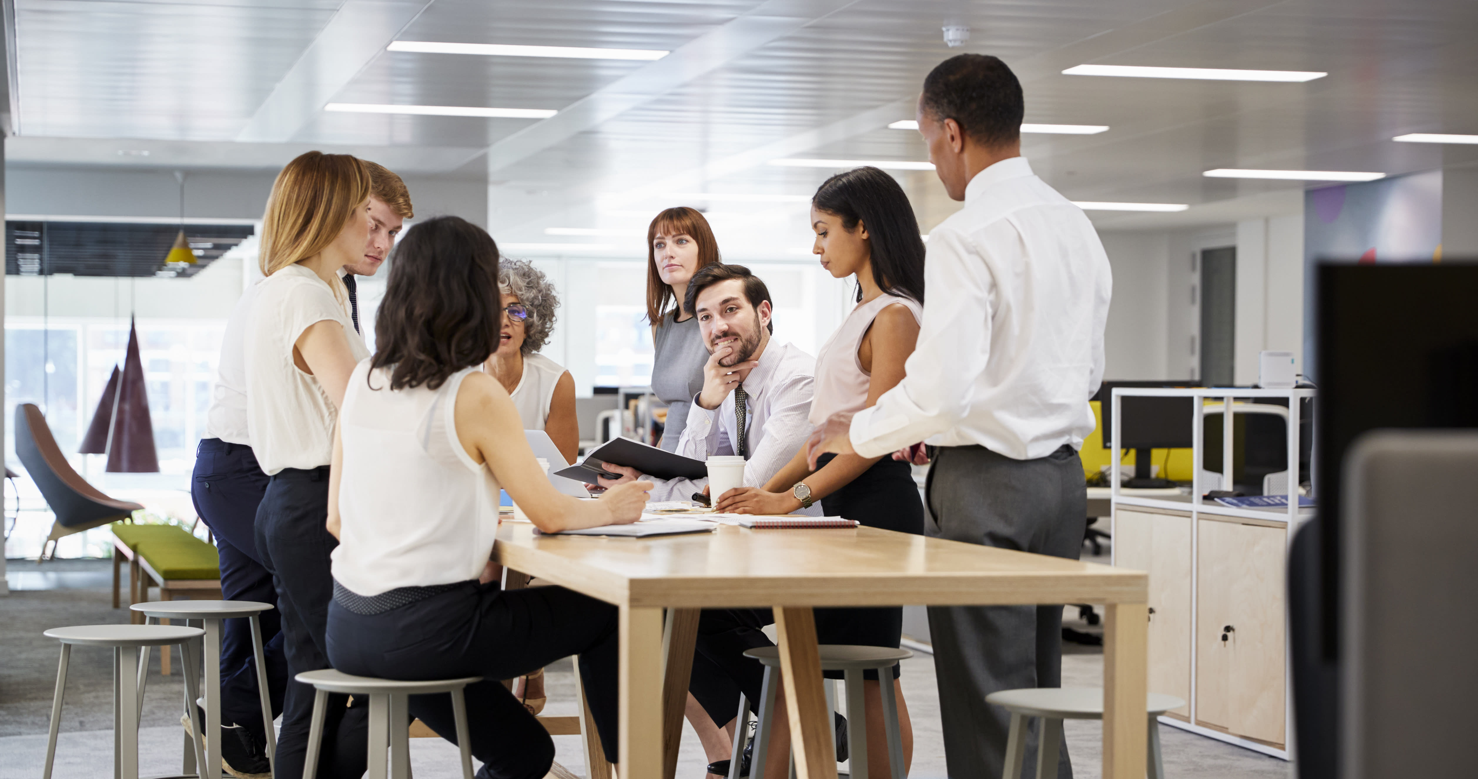 Colleagues discussing a Lean Six Sigma process improvement project in an office