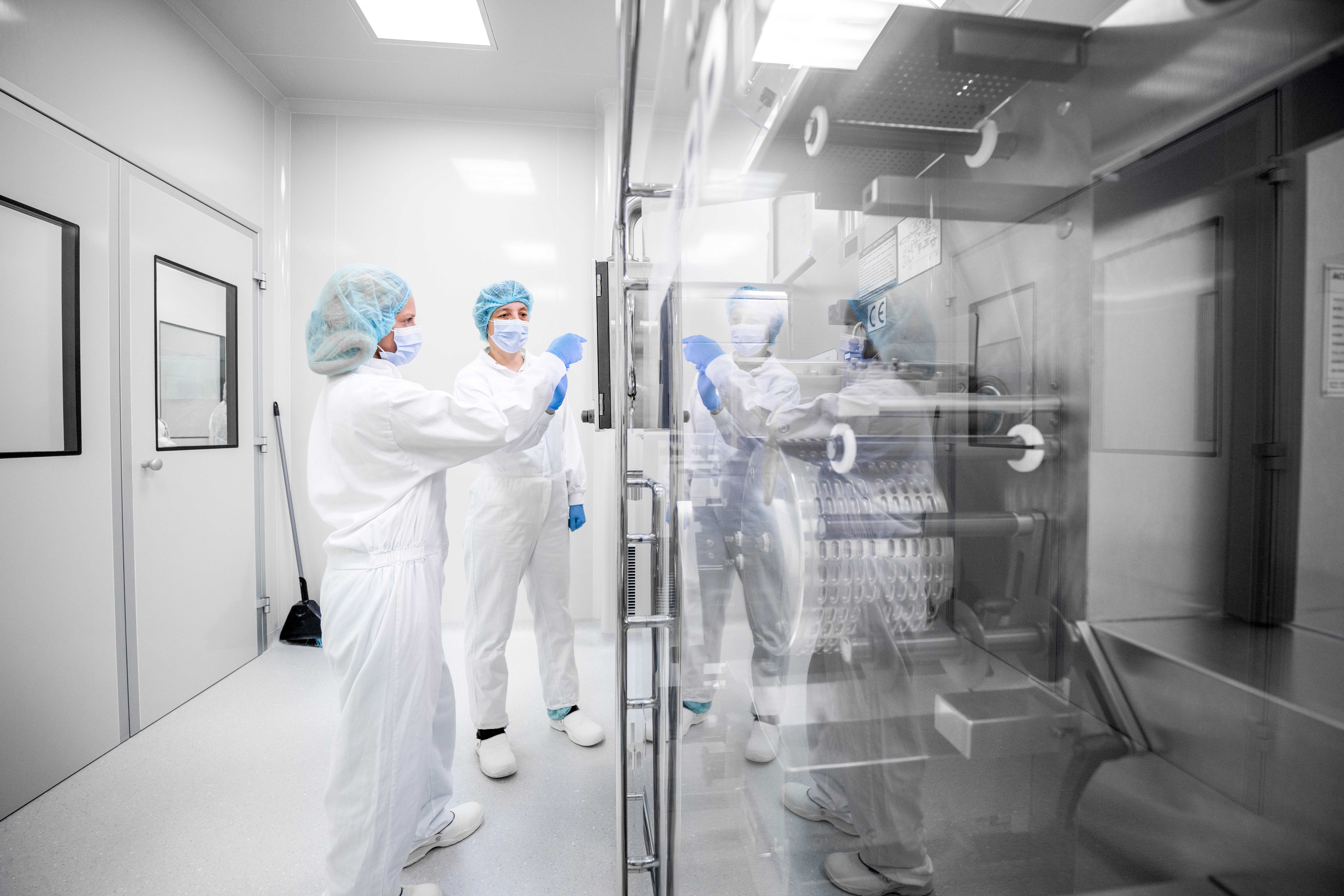 Imagen de dos trabajadoras en una sala de laboratorio con protección EPI
