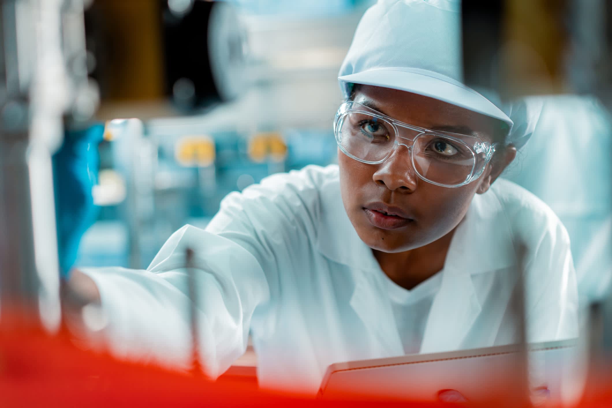 An inspector in a food processing factory conducting a health inspection on a batch of food.
