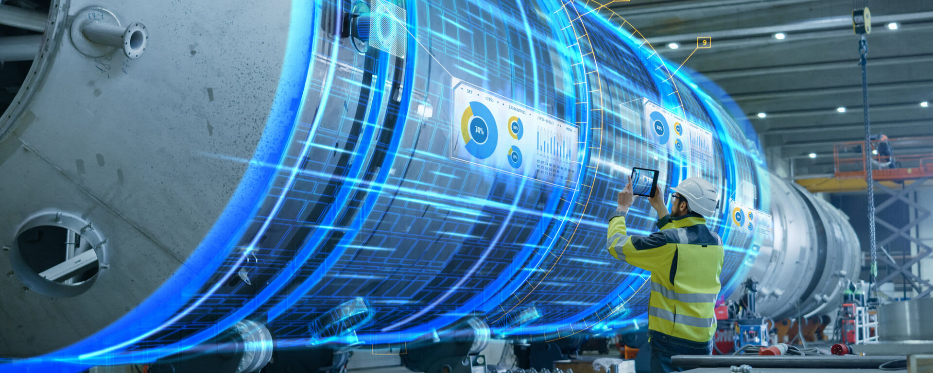 An engineer inspecting a digital projecting of a large vehicle engine with a tablet, and metrics and data being displayed on the panels of the engine.