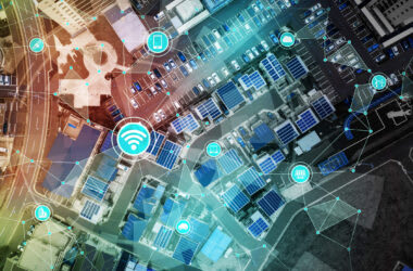 A birds-eye view of a town highlighted with blue and orange accents, with internet connectivity icons connecting to represent LoRaWAN technology.