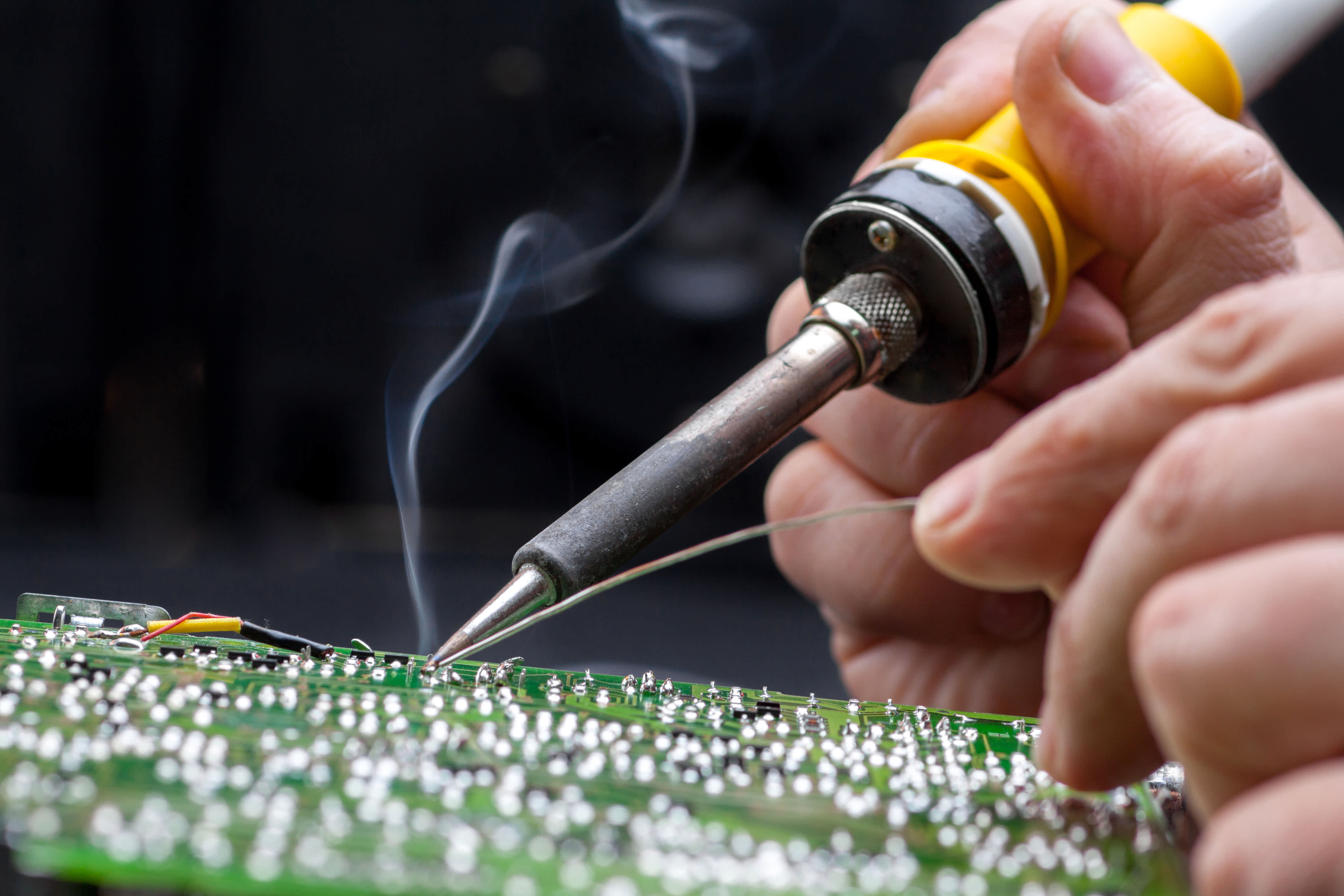 person soldering a circuit board