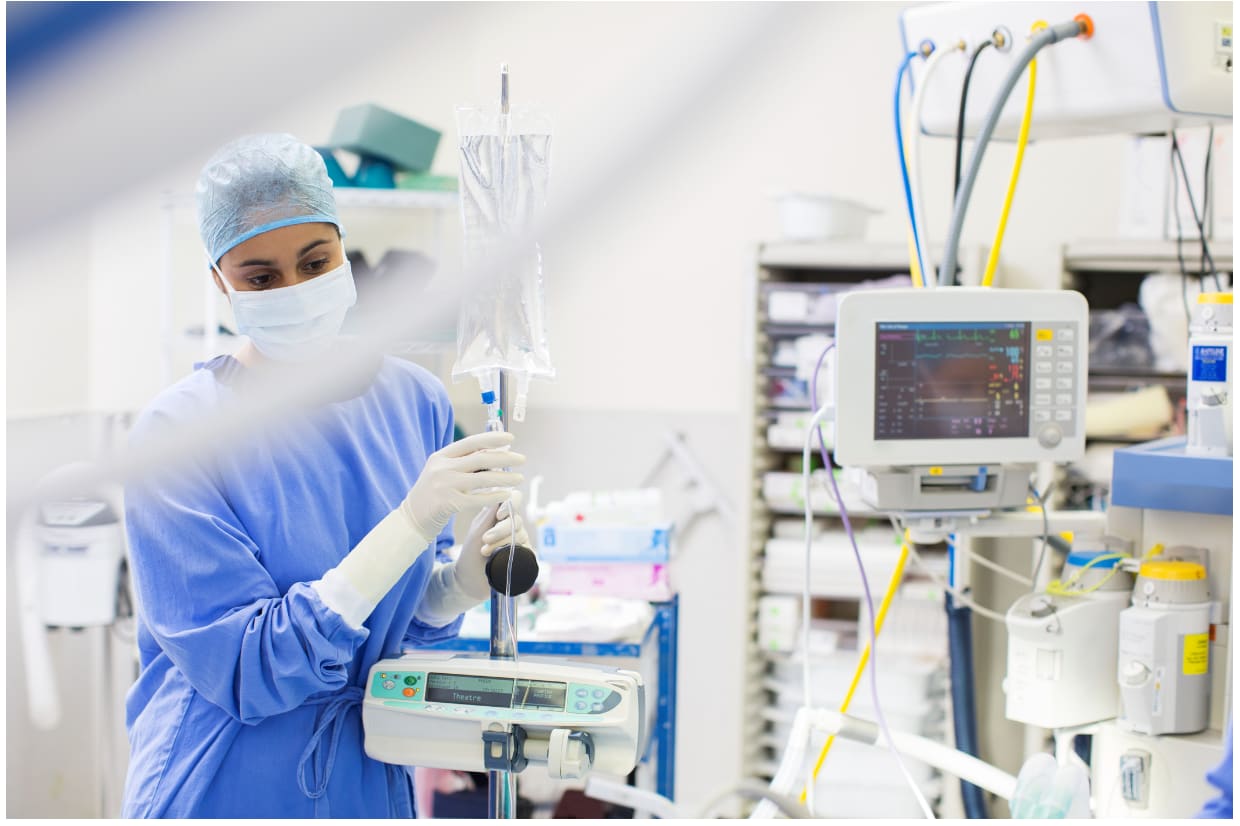 A nurse in a hospital room decontaminating medical devices